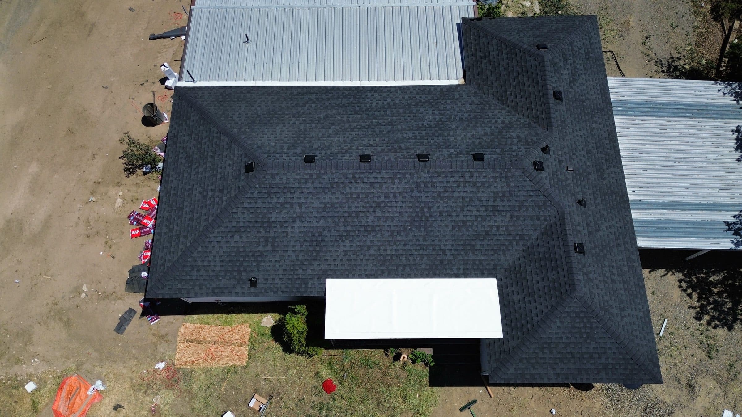 Aerial view of a finished dark grey shingle roof