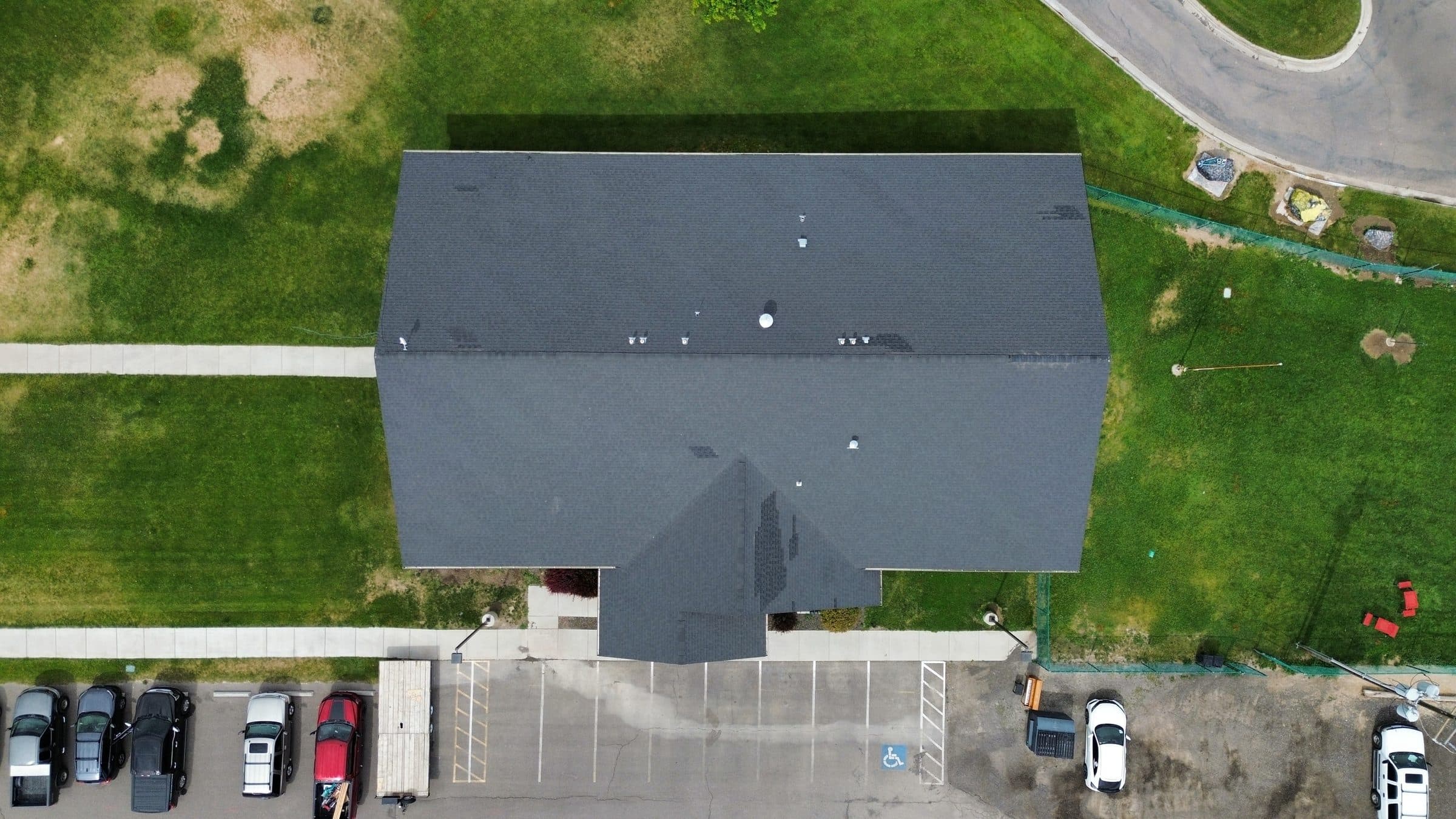 Aerial view of a finished roof with dark shingles, alternate angle